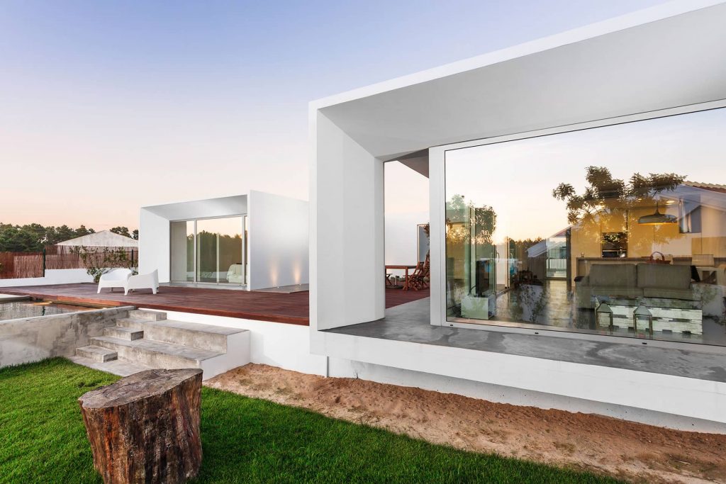 Contemporary home with glass walls, a garden, and a swimming pool